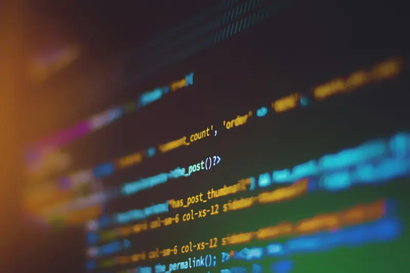 Out-of-focus lines of colourful template code on a dark screen